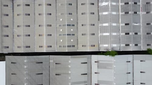 Aerial view of a goods distribution warehouse lined up with goods trucks parked in front of the ware