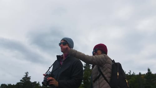 Young couple hiking through majestic forest mountains taking photos of nature