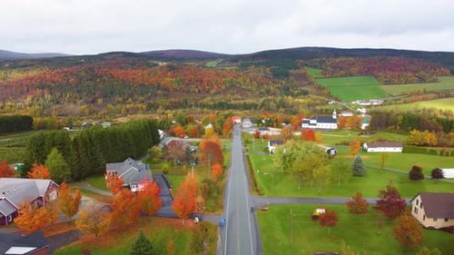 Colorful autumn scenery in a rural Canadian town with vibrant trees and rolling hills in Estrie