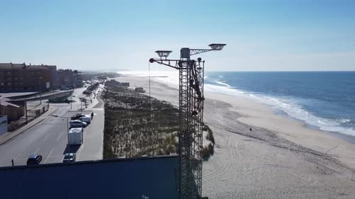 Aerial view of parking cars, dunes and sandy beach with blue ocean of Portugal during summer day
