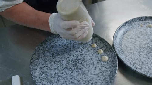 Chef Plating Gourmet Dish with Squeeze Bottle
