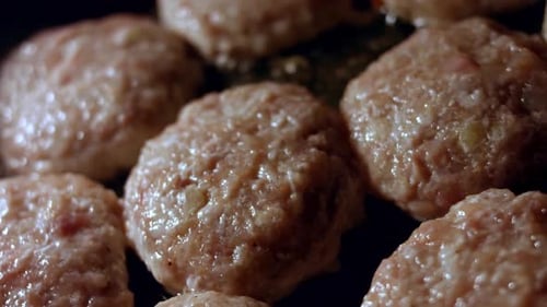 Juicy Delicious Meat Cutlets are Fried in Oil on Black Pan