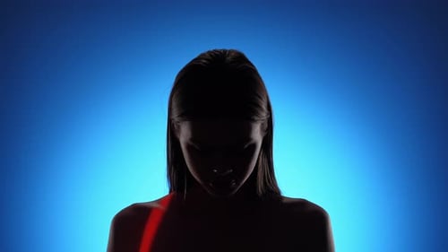 Une personne mystérieuse avec un effet de lumière bleu et rouge spectaculaire