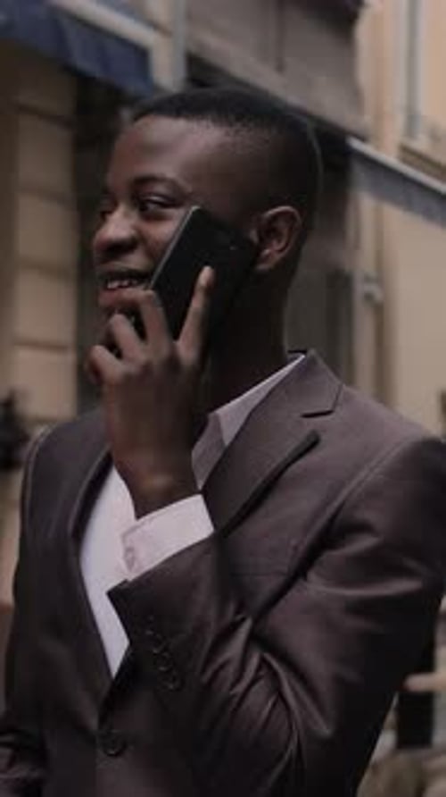 Smiling Man in Suit on Phone on Urban Street