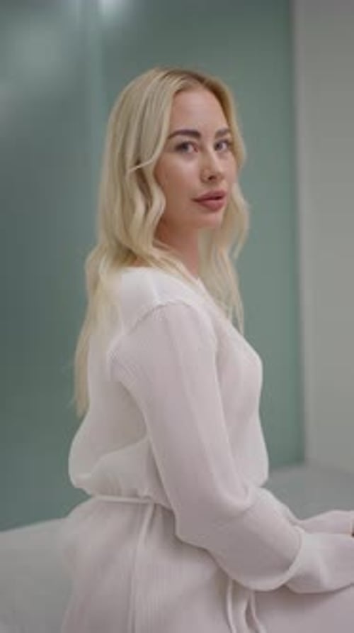 Elegant Blonde Woman in White Dress Posing Indoors