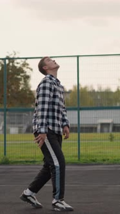 Man Tossing Volleyball in Outdoor Court Preparing to Strike