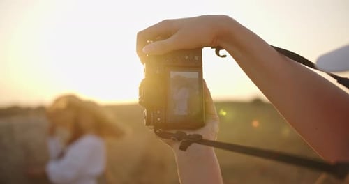 A Girl Photographs a Model in a Field at Dawn