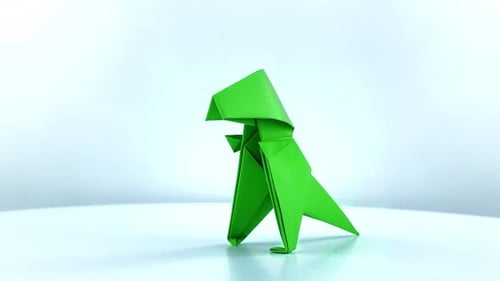 Los T-rex de origami giran sobre una superficie blanca