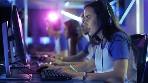 Focused Gamers Playing at Computers in Gaming Arena