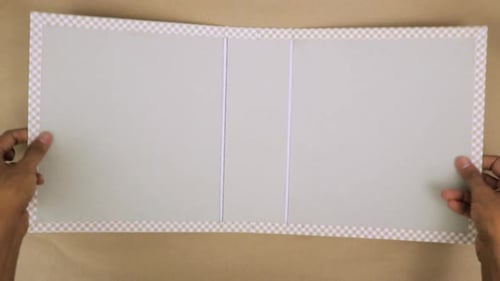 Hands Folding a Checkered Trim Folio