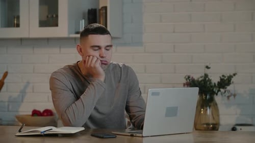 Bored Businessman Working at a Computer in His Home Office Freelancer Begins to Feel Tired By the