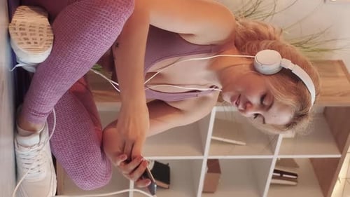 Woman Listens to Music on Mobile Phone