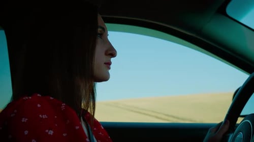 Woman Driving a Car Through Rural Landscape