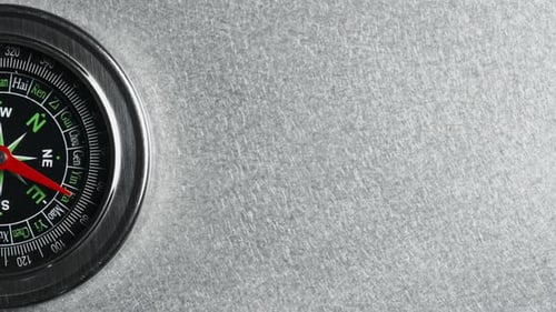 Primer plano de una brújula de precisión sobre un fondo gris texturizado