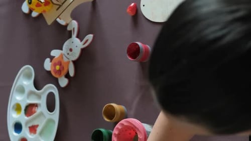 Top View of Mother Painting Egg for Easter