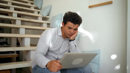 Sleepy Man Looks at Screen of Laptop Listening to Lesson