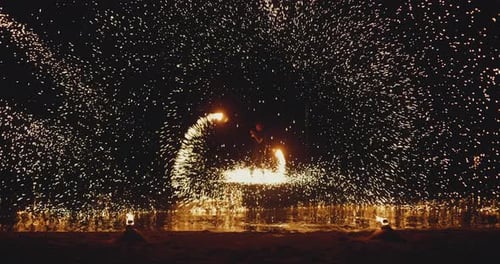 Man Performing Fire Show at Nighttime on the Beach in Slow Motion