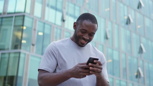 Happy African American Man Euphoric Winner with Smartphone on Street in City Person Guy Looking at