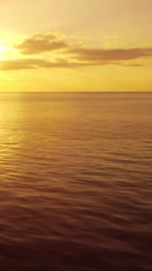 La caméra de vue aérienne verticale de la surface de l'eau de mer au coucher du soleil survole la mer dorée calme et éblouissante