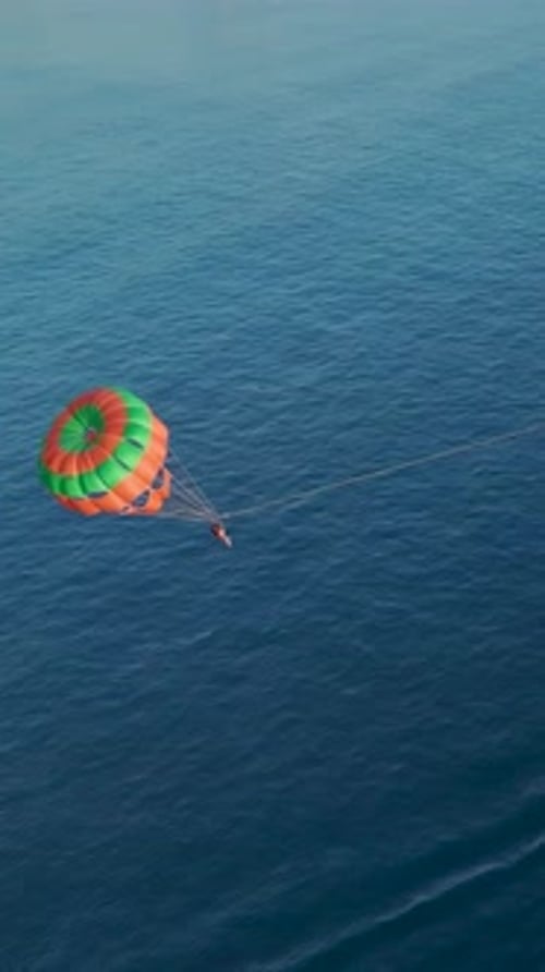 Vertikales Video Parasailing erfreut Touristen, die über kristallklarem Wasser schweben