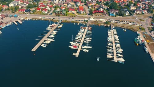 Panoramic view of marina in Jastarnia with moored yachts and boats and city in the background