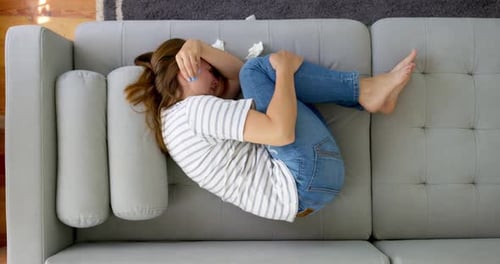Woman Lying on Sofa in Fetal Position