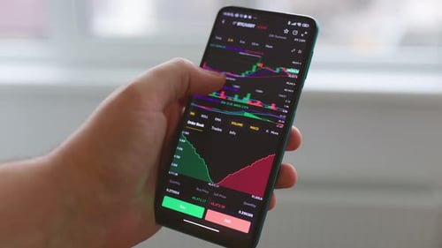 Close Up Businessman Finger Working with Stock Market Data Graph on a Smartphone