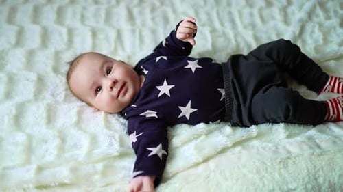 Smiling Baby Lying on a Blanket Indoors