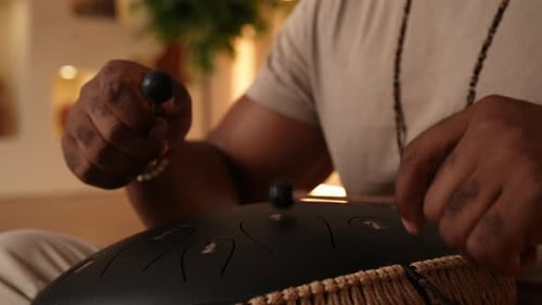 Extreme Closeup of Unrecognizable Spiritual African Man in Trance Sitting Playing on Steel Tongue