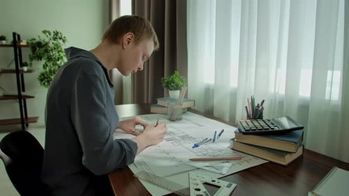 Junger Architekt arbeitet fleißig an Architekturzeichnungen