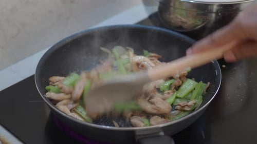 Stir Frying Chicken, Peppers and Onions in Pan
