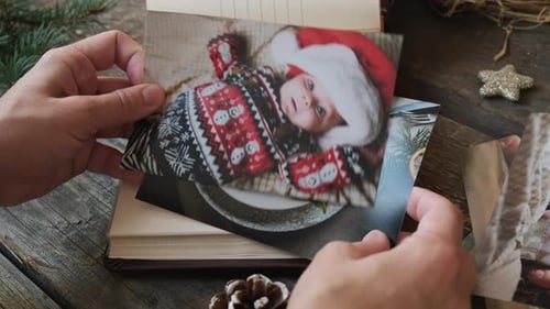 Impresión fotográfica de manos femeninas navegando por fotos impresas de Navidad