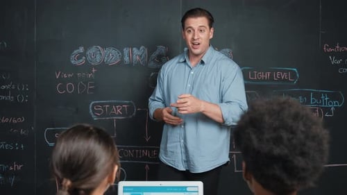 Handsome teacher teaching engineering code to diverse student. Edification