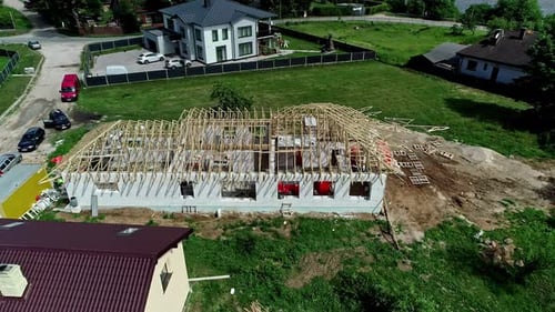 Aerial view around a roof frame at a house construction site, summer day