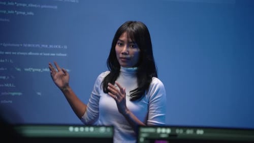 Female Software Engineer Presenting Code Lecture On Big Screen