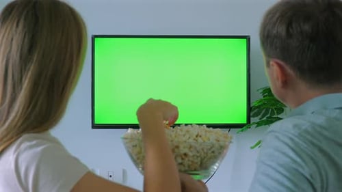 Couple Enjoys Popcorn Watching TV with Green Screen