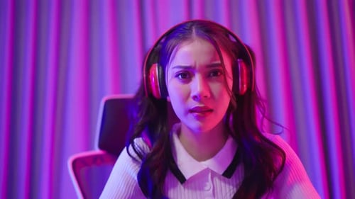 Young Woman Plays Video Game with Headphones