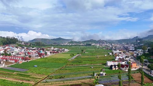 Panoramic view of a fertile highland region with agricultural fields, modern houses