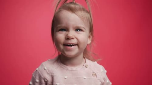 Nahaufnahme: Lächelndes kleines süßes Mädchen, das wie ein Kind aussieht und lustig, verspielt lacht