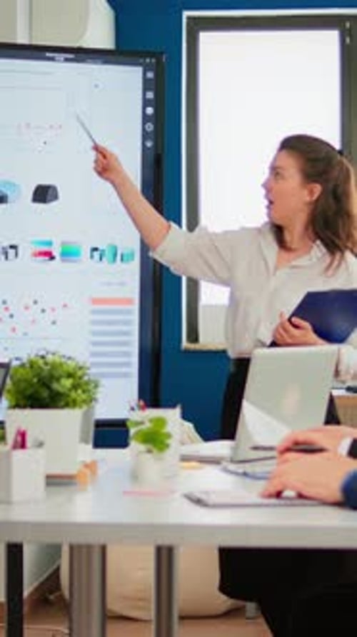 Confident Businesswoman Presenting Data Charts in Office