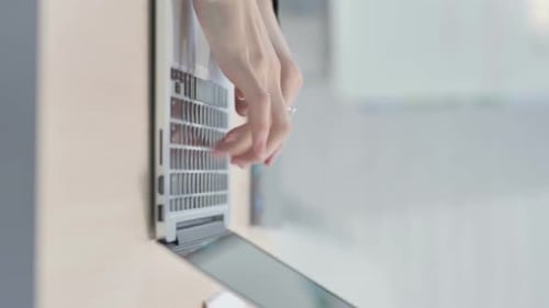 Hands Typing on Laptop Keyboard in Office