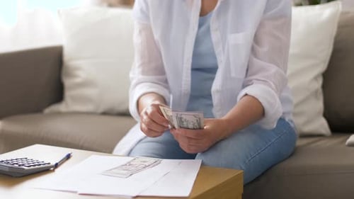 Woman Managing Finances at Home with Calculator