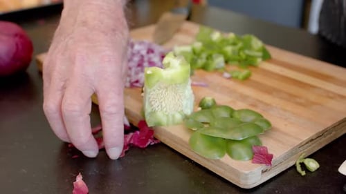 Midsection of senior caucasian man cleaning vegetable peels in kitchen at home, slow motion