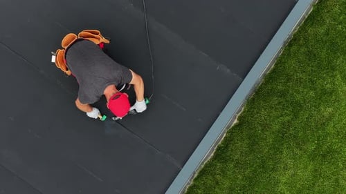 Roof EPDM Repair Work Being Done on a Residential Building in a Suburban Area