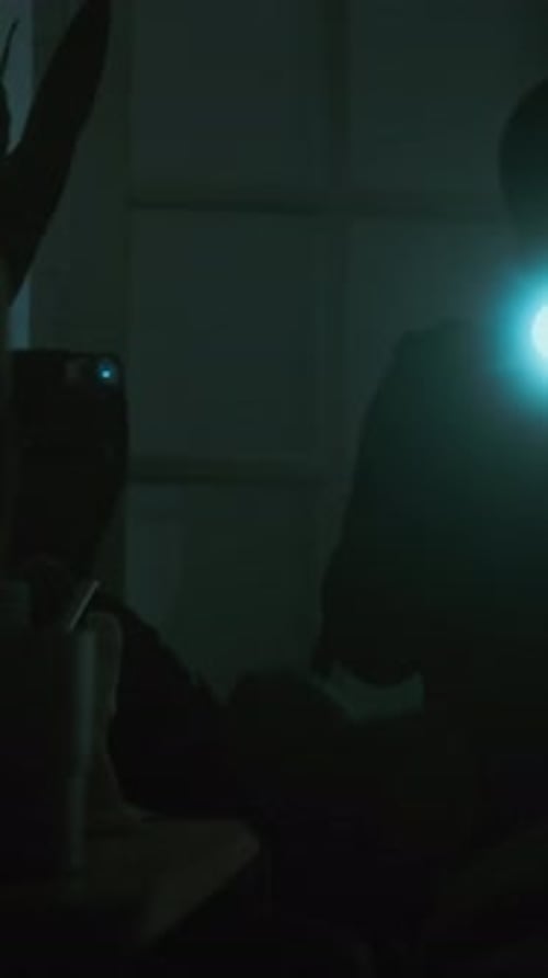 Silhouette in Dark Room With Flashlight