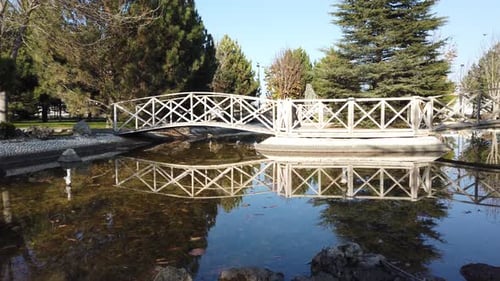 Weiße Holzbrücke über den Zierteich im Park