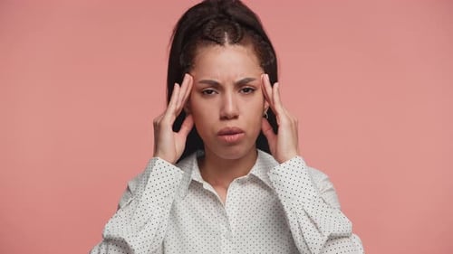 Woman Rubs Temples in Discomfort