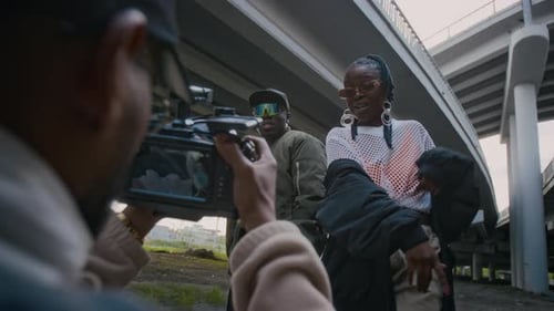 Videographer Shooting Hip-Hop Artists Rapping Outdoors in Urban Area