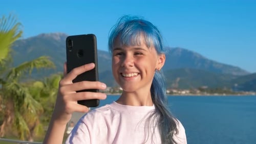 Happy Teen Video Calling at Beautiful Seaside Location