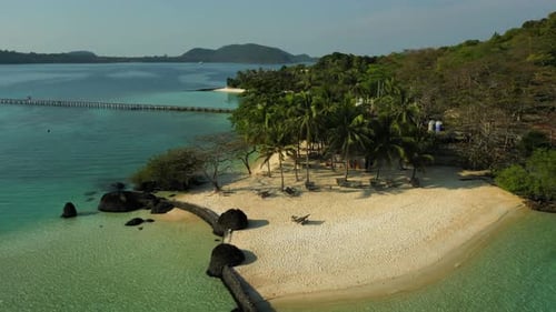Flyover abandoned beautiful beach on island with palm trees in Thailand during summer day